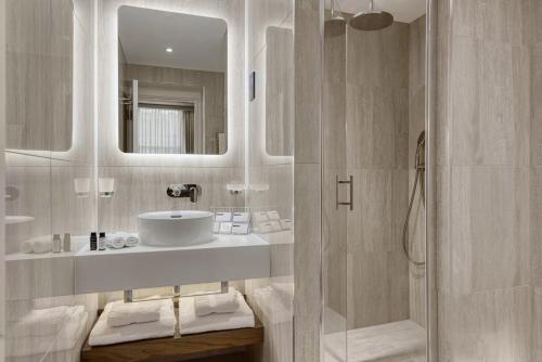 伦敦阿巴伦敦皇后大门酒店的白色的浴室设有水槽和淋浴。