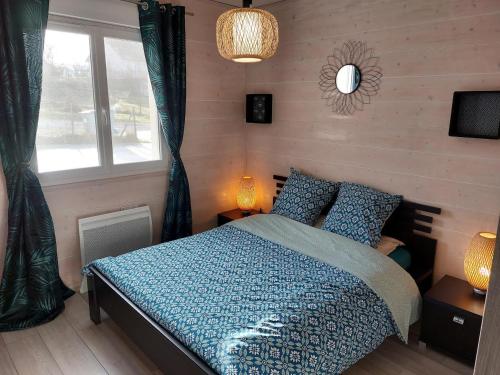 Barésia-sur-lʼAinEntre Lacs Et Montagnes , Maison individuelle, lits préparés et ménage inclus的一间卧室配有一张带蓝色棉被的床和窗户。