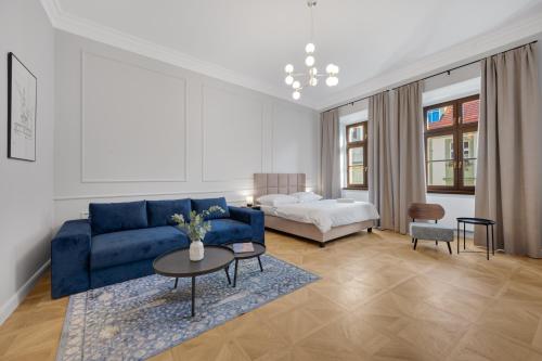 布拉迪斯拉发Palace Apartments的客厅配有蓝色的沙发和床。