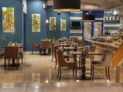 伊泰阿Trokadero Boutique Hotel的餐厅设有桌椅和蓝色的墙壁
