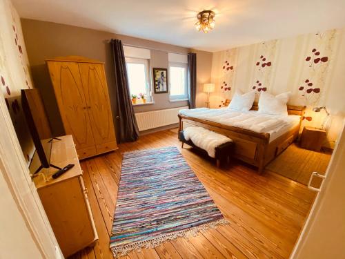 OrtenbergGemütliche Landhaus Wohnung auf dem Ponyhof - Himmelbett, Kamin & Garten的一间卧室配有一张床和地毯