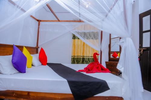 米瑞莎Sajana Ocean Hill的一间卧室配有带色彩缤纷枕头的床