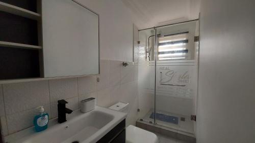东勒贡Lovely 1 & 2 Bed Apartment at RealShala Homes - East Legon Hills的一间带水槽和玻璃淋浴的浴室
