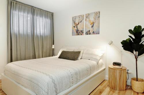 斯托纳姆100 Chemin des Ruisselets的白色的卧室设有白色的床和窗户。