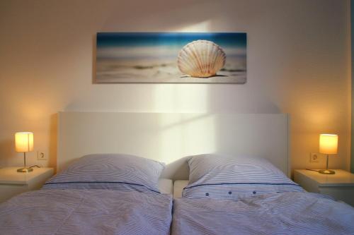 奥斯特巴特宁哈根Ferienwohnung Meeresrauschen的卧室配有一张墙上的贝壳床