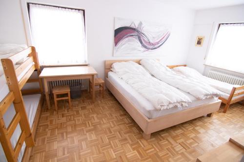 诺伊马克特Familienzimmer的一间卧室配有一张床、一张书桌和两个窗户。