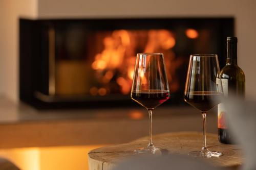 上施陶芬Wald Lounge的壁炉前的桌子上放着两杯葡萄酒