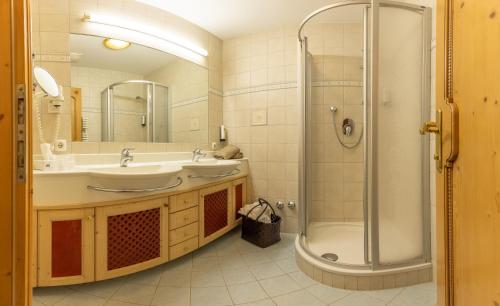 迈尔霍芬圣乔治酒店的带淋浴、盥洗盆和浴缸的浴室