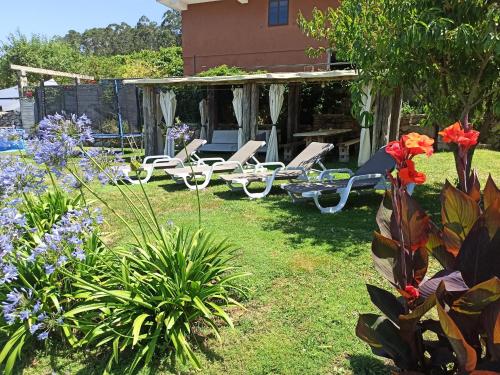 Santa CristinaCasa De Campo Clara的庭院内带椅子和鲜花的花园