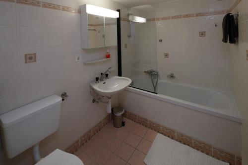 克莱恩 蒙塔纳Magnifique appartement proche du centre et du ski的浴室配有盥洗盆、卫生间和浴缸。
