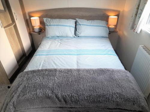 米勒姆3 Bedroom Modern Caravan Sleeps up to 8的小房间的一个床位,配有两个枕头