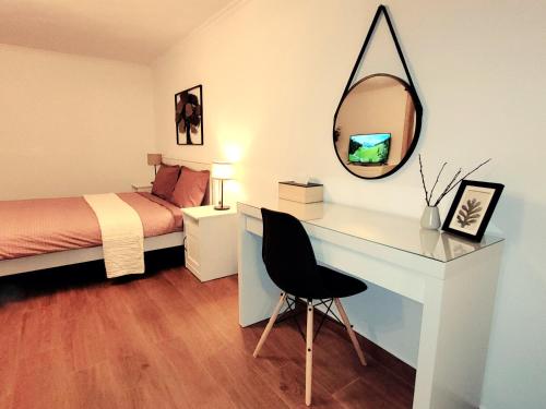 布加勒斯特Rose Garden House的一间卧室配有一张床和一张带镜子的书桌