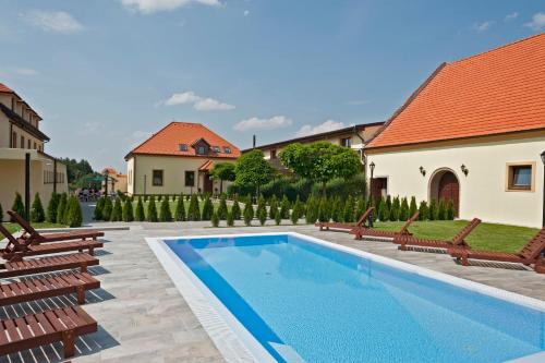 布赫洛维采布赫洛维酒店的一个带长椅和房子的庭院内的游泳池