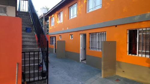 阿肖海Don Pocho的一座橙色的建筑,楼梯通往门