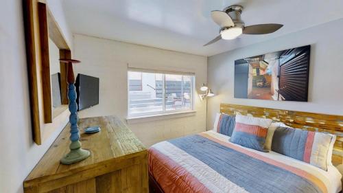 摩押Moab Flats #3的一间卧室配有一张带书桌和电视的床。