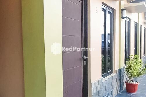 Poponcal 2Ardico Residence Syariah Mitra RedDoorz的建筑物一侧的黑色门