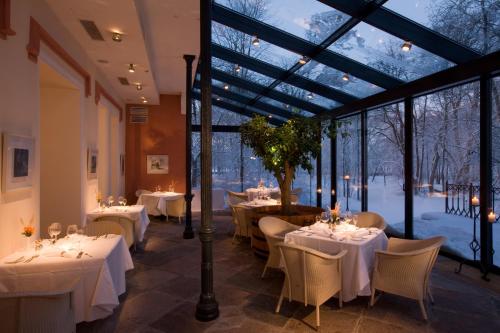 帕达斯特帕达斯特庄园酒店的餐厅设有白色的桌椅和窗户。