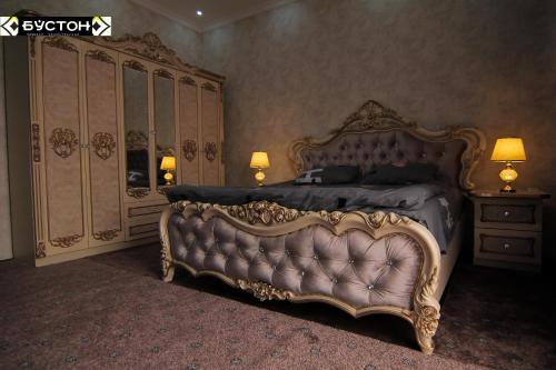 ChkalovskHotel Buston的一间卧室配有一张特大号床和梳妆台