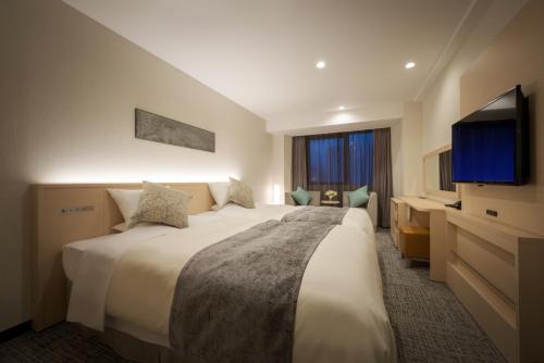 盛冈皇家盛岗酒店的一间酒店客房,配有一张大床和一台平面电视
