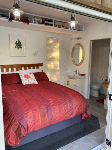 OhauitiThe Treehut的一间带红色床的卧室和一间浴室