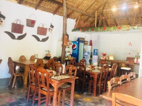 BantaoayRedDoorz Hostel @ Deomar Hometel & Farm Cafe Ilocos Sur的用餐室配有木桌和椅子