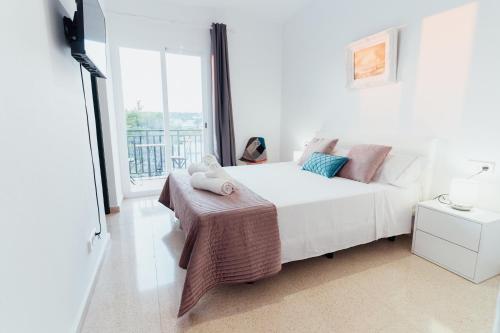 蓬塔普里马Hostal Noray的卧室设有白色的床和大窗户