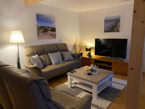 OsteelLandhaus "Alte Welt" Nordseeküste的带沙发和电视的客厅