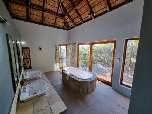 贝拉贝拉Livingstone Bush Lodge, Mabalingwe的大型浴室设有两个盥洗盆和浴缸。