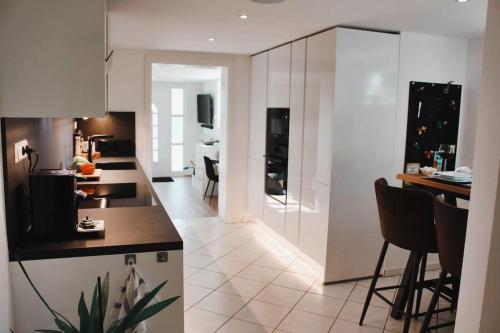 加格瑙Smart-Apartment BlickWinkel Schwarzwald的厨房配有白色橱柜和桌椅
