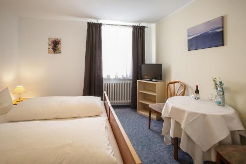 苏尔茨堡Landgasthof Rebstock的酒店客房设有两张床和一张桌子。