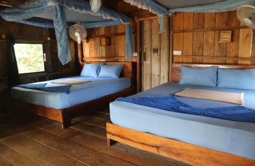 高龙撒冷岛Lazy Beach的木墙客房的两张床