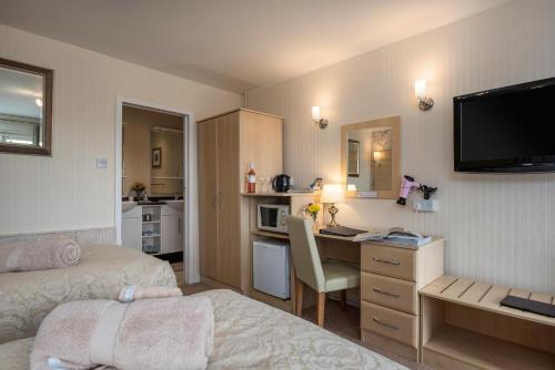 塔桑墨Estuary Lodge Motel B&B的酒店客房配有一张床、一张书桌和一间厨房。