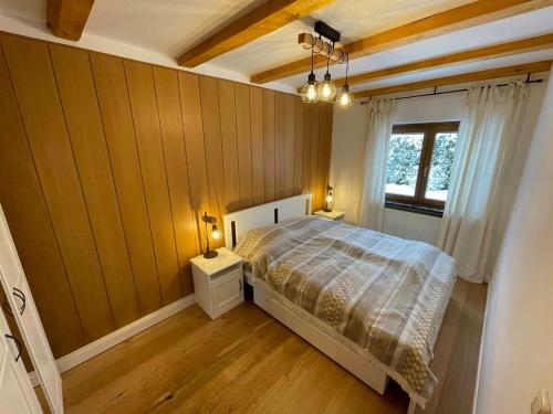 海德米赫莱Ferienhaus Marchhäuser 12的一间卧室配有一张带木墙和窗户的床。
