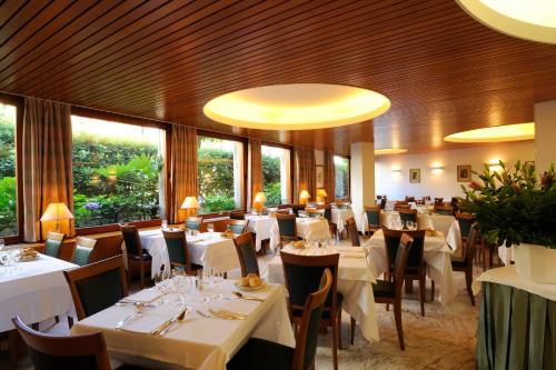 阿拉西奥玛吉斯迪克酒店的餐厅设有白色的桌椅和窗户。