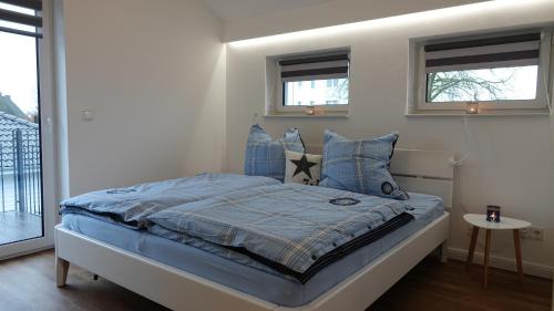 奥茨塞巴德·迪尔哈根"GESTRANDET" in der Villa Katharina-的一间卧室配有一张带蓝色床单和枕头的床。