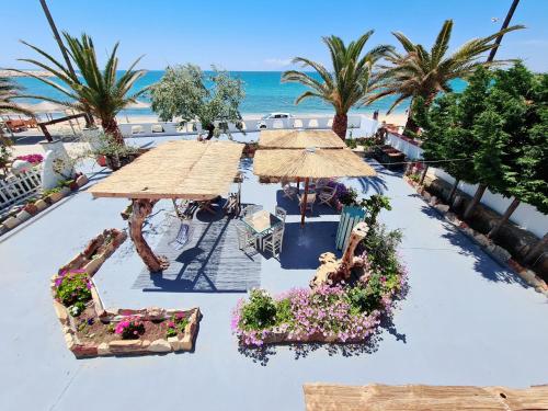 利迈纳里亚Votsalo Cozy Apartments的享有海滩的空中景致,配有遮阳伞和鲜花