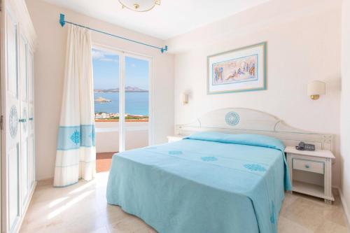 巴哈撒丁岛Club Hotel Cormorano的一间白色的卧室,配有一张床,享有海景