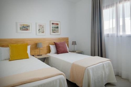 普拉亚布兰卡Villas Altos de Lanzarote的酒店客房设有两张床和窗户。
