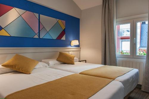 维多利亚-加斯特伊兹Hotel Hito的两张位于酒店客房的床,墙上挂着一幅画