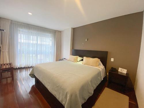 波哥大Apartasuites BellHouse Bogotá的一间卧室设有一张大床和一个大窗户