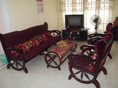 卡卢特勒Anura Home Stay的客厅配有沙发、椅子和电视