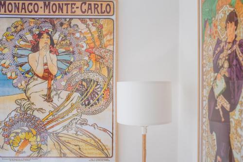 巴科利Naro Suites and Rooms的灯旁一幅画画,画着一个女人和一个龙