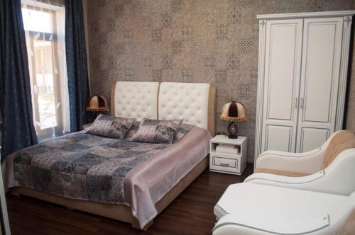 MartuniAhana Hotel in Martuni的一间卧室配有一张大床和两把椅子