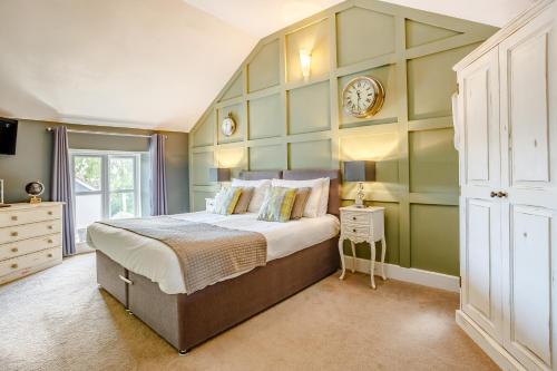 切普斯托Broadrock Accommodation - Clock Cottage的一间卧室设有一张大床和绿色的墙壁