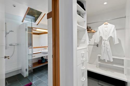 皇后镇Brunswick Lodge - Luxury - Central Queenstown的浴室配有步入式淋浴间和白色浴袍