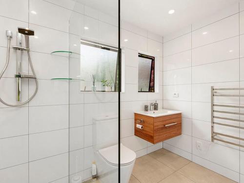 陶波Matuku Hideaway - Taupo Holiday Home的白色的浴室设有卫生间和水槽。