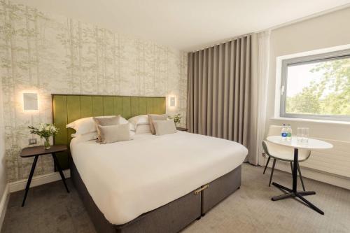 基尔肯尼The Hoban Hotel Kilkenny的卧室配有一张白色的大床和一张桌子