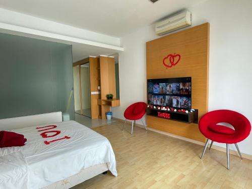 吉隆坡Private Jacuzzi Staycation at KL City 152的一间卧室配有两张红色椅子和一张床