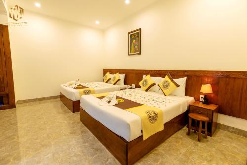 潘切Thọ Hướng Hotel - Phan Thiết的酒店客房,设有两张床和一盏灯