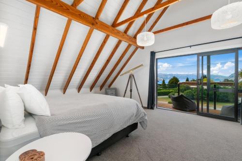 哈威亚湖Views on Parry - Lake Hāwea Holiday Home的一间卧室设有一张床和一个大窗户